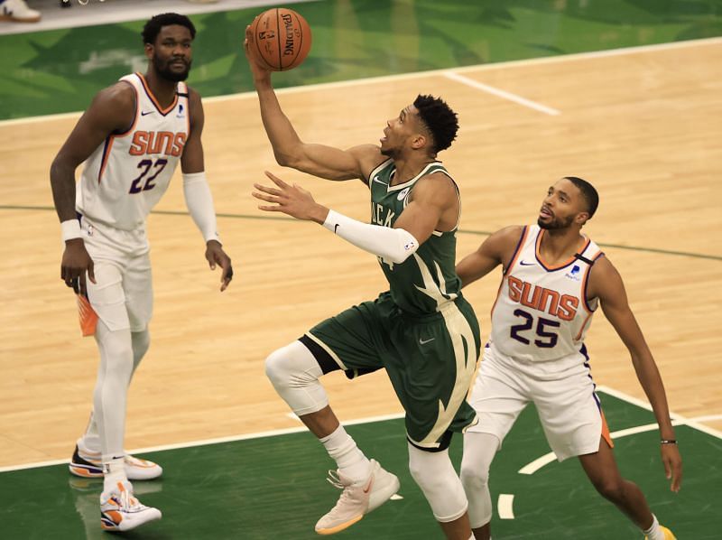 Giannis Antetokounmpo #34 drives past Mikal Bridges #25. caption