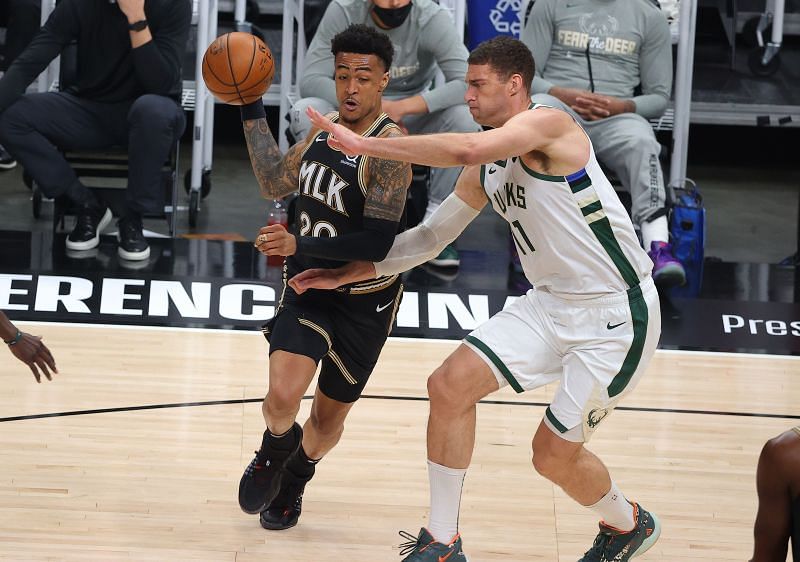 John Collins #20 drives against Brook Lopez #11