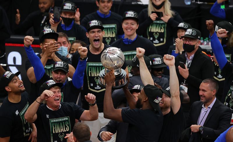Members of the Milwaukee Bucks hold the Eastern Conference Finals trophy.
