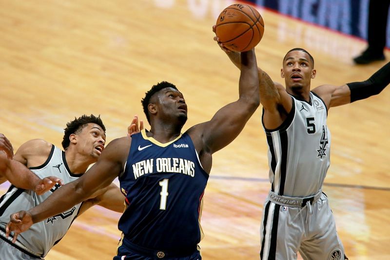 Zion Williamson (#1) pulls down a rebound against Dejounte Murray (#5).