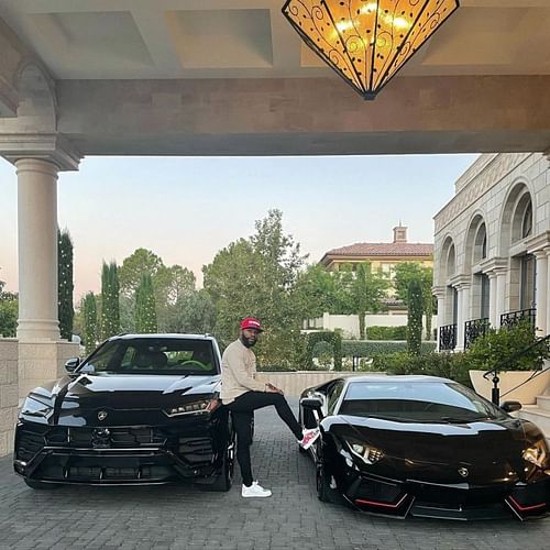 Floyd Mayweather poses with two of his cars | Image via Instagram @floydmayweather