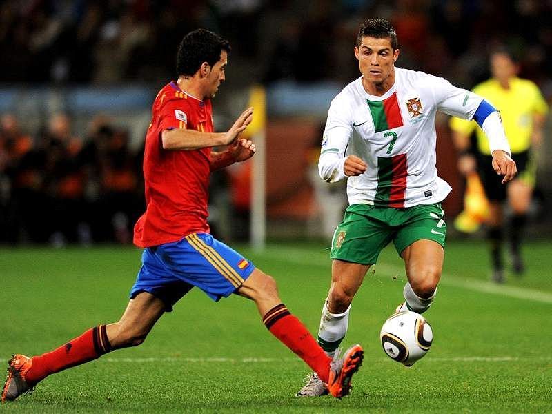 Cristiano Ronaldo dribbling past Sergio Busquets of Spain
