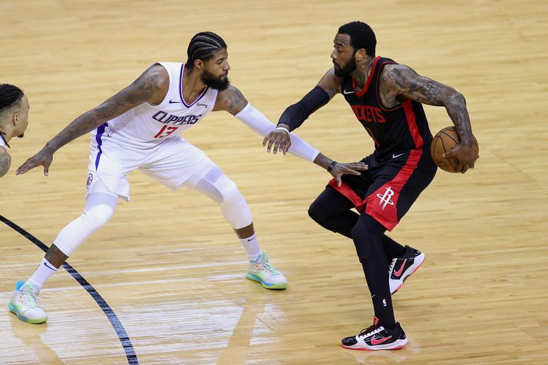 John Wall (#1) of the Houston Rockets dribbles against Paul George (#13)
