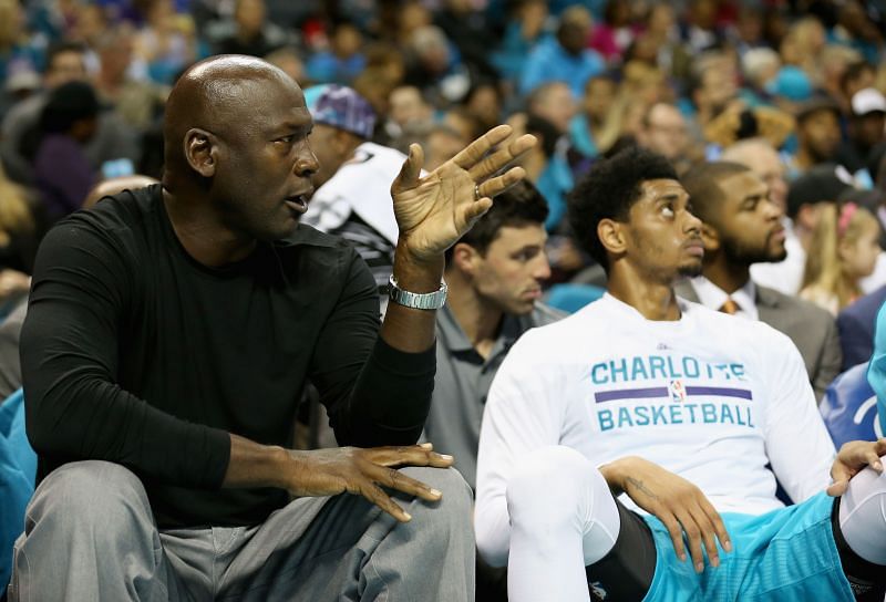 Michael Jordan sits courtside during a Charlotte Hornets game