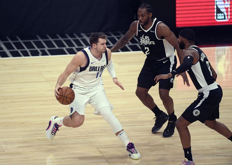 Luka Doncic (#77) is double teamed by Kawhi Leonard (#2) and Marcus Morris Sr.