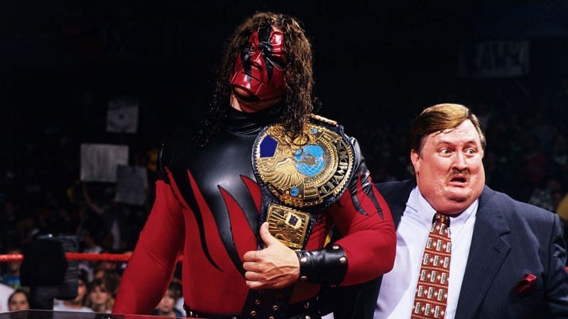 Kane (real name - Glenn Jacobs) as the WWE Champion, flanked by Paul Bearer