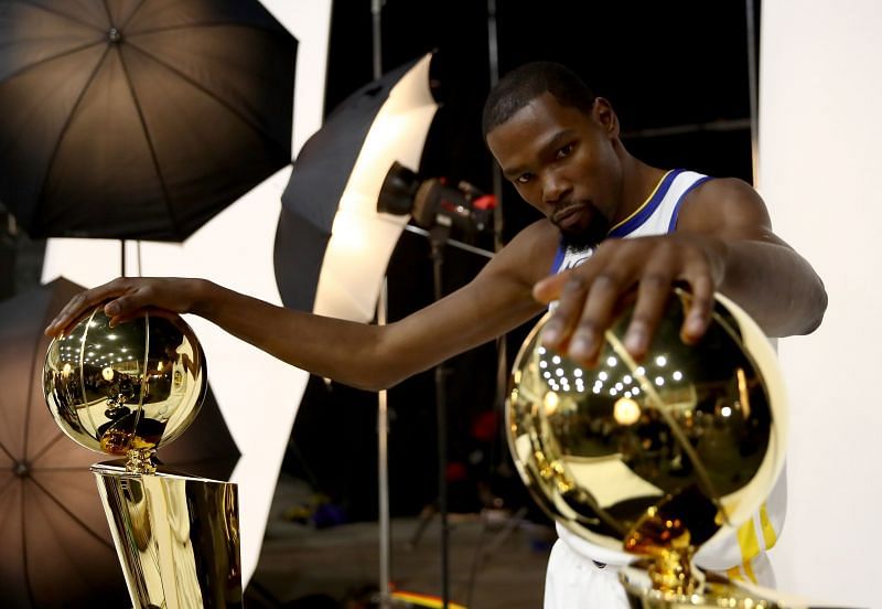 Kevin Durant poses with two Larry O&#039;Brien NBA Championship Trophies.