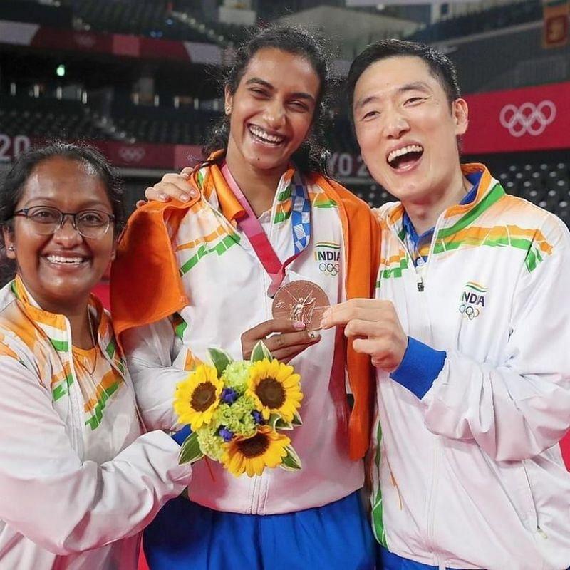 PV Sindhu flashing her bronze medal. Evangeline Baddam and coach Park Tae Sang are also seen