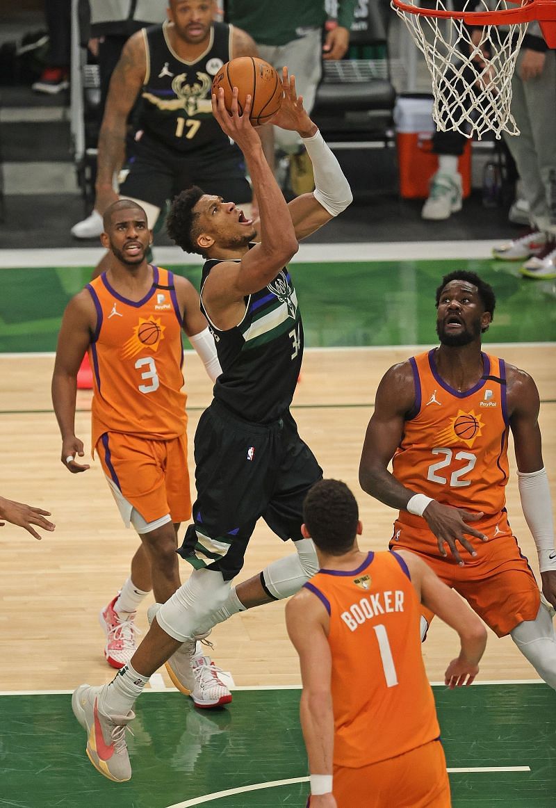 Giannis Antetokounmpo (#34) of the Milwaukee Bucks goes up for a shot over (L-R) Chris Paul (#3), Deandre Ayton (#22) and Devin Booker (#1)