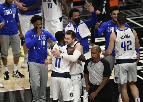 Luka Doncic (#77) of the Dallas Mavericks hugs Tim Hardaway Jr. (#11)