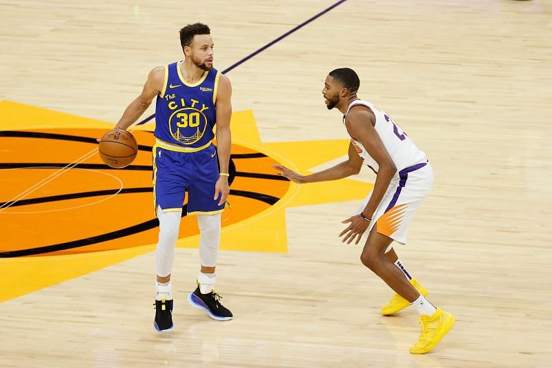 Stephen Curry #30 of the Golden State Warriors handles the ball against Mikal Bridges #25 of the Phoenix Suns