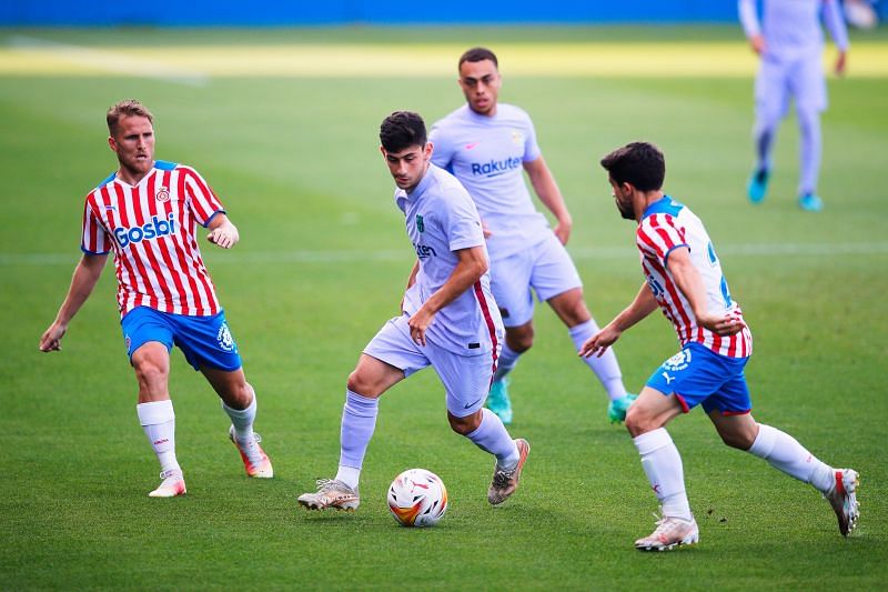 Yusuf Demir (centre) of Barcelona in action against Girona