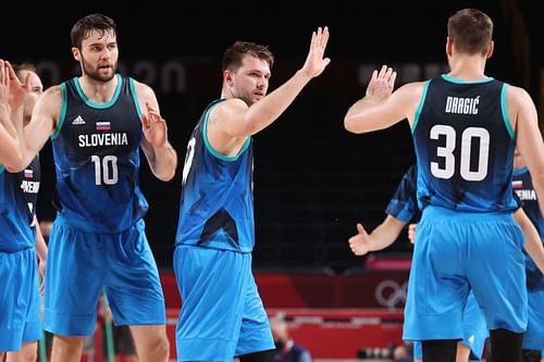 Mike Tobey #10, Luka Doncic #77, and Zoran Dragic #30 of Team Slovenia celebrate after defeating Spain