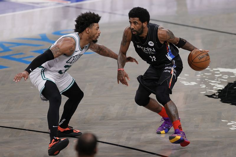 Kyrie Irving (#11) of the Brooklyn Nets dribbles as Marcus Smart (#36) of the Boston Celtics looks on.