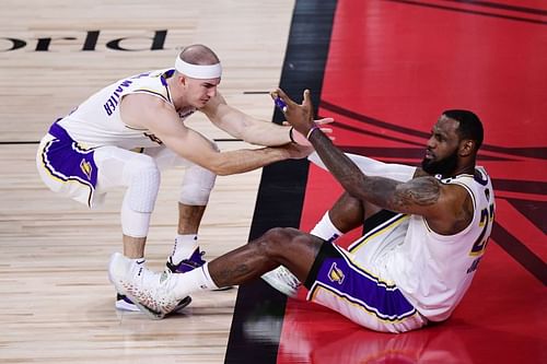 Alex Caruso (Left) helps LeBron James (right) to his feet