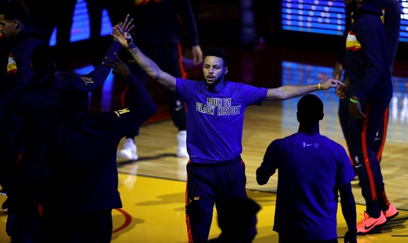 Stephen Curry high-fives his teammates before the start of a game.