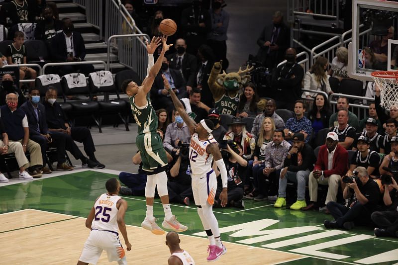 Giannis Antetokounmpo takes a contested fadeaway over Torrey Craig