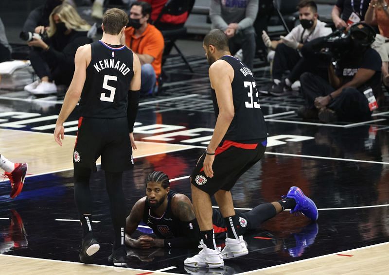 Paul George #13 of the LA Clippers reacts as he falls to the court under Luke Kennard and Nicolas Batum.