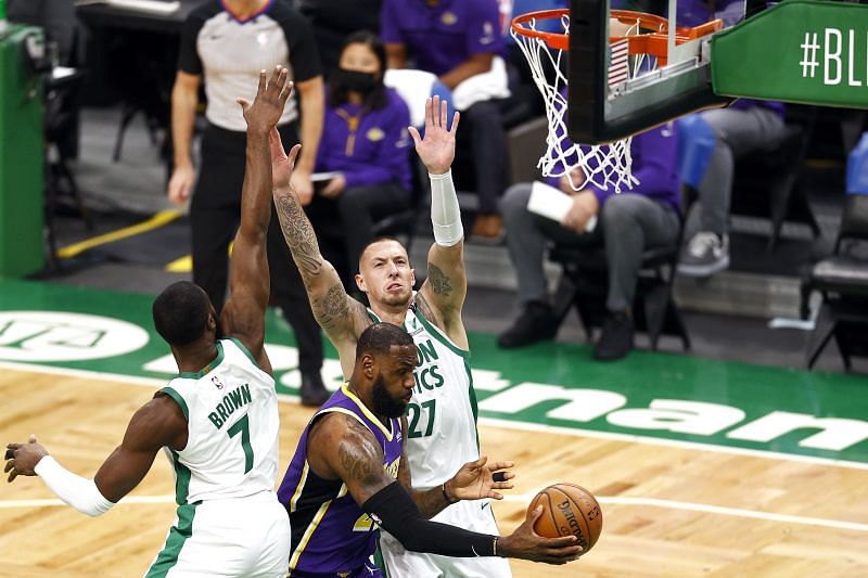 LeBron James (#23) makes a pass between Jaylen Brown (#7) and Daniel Theis (#27).