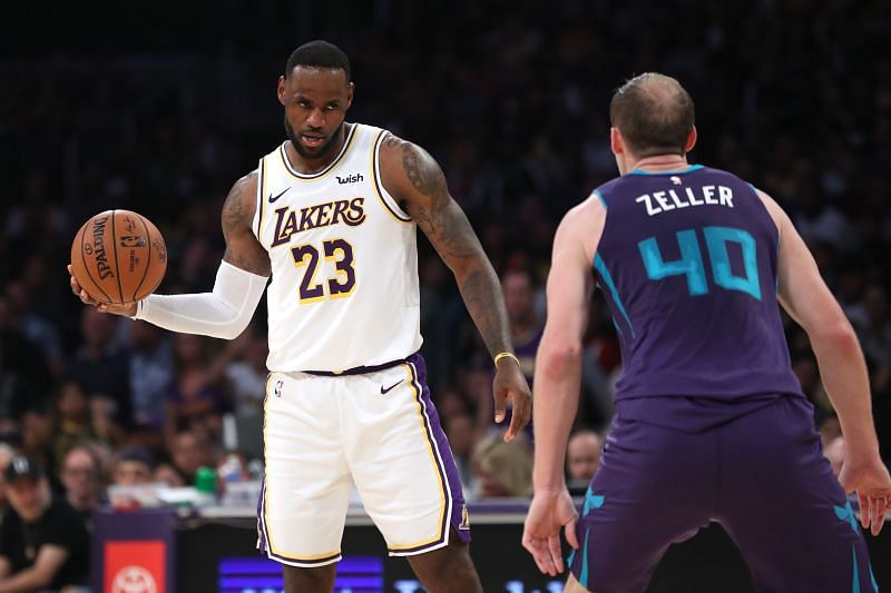 LeBron James #23 of the Los Angeles Lakers controls the ball as Cody Zeller #40 of the Charlotte Hornets defends