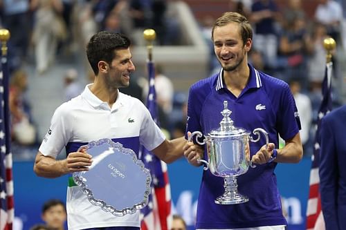 Novak Djokovic and Daniil Medvedev pose for photos during the 2021 US Open trophy ceremony