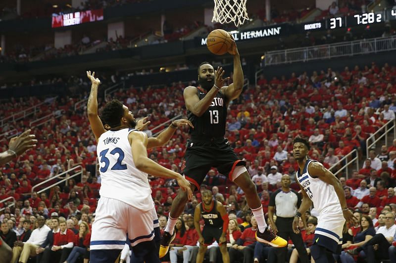 James Harden #13 of the Houston Rockets passes under the basket defended by Karl-Anthony Towns #32 of the Minnesota Timberwolves in the first half during Game Five of the first round of the 2018 NBA Playoffs at Toyota Center on April 25, 2018 in Houston, Texas.