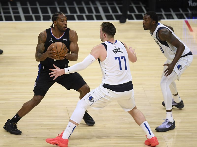 Kawhi Leonard (#2) of the LA Clippers looks to pass out of a double team from Luka Doncic (#77) and Dorian Finney-Smith (#10).