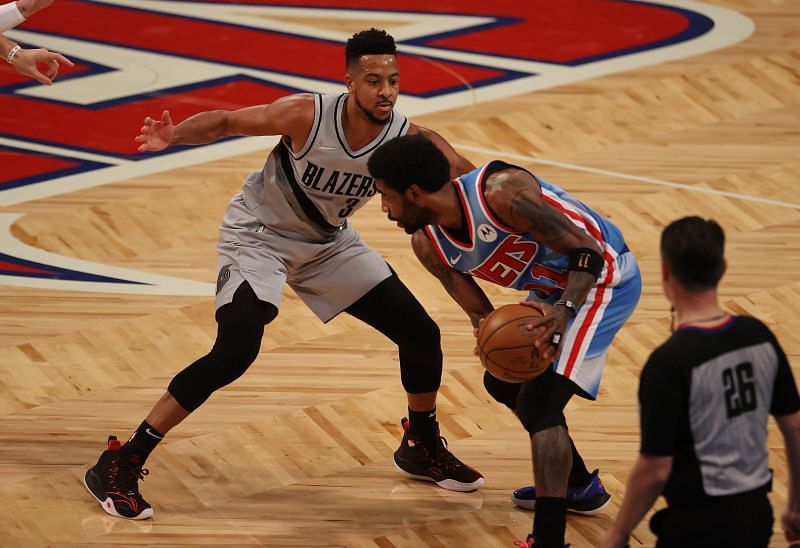 Kyrie Irving #11 of the Brooklyn Nets dribbles against CJ McCollum #3 of the Portland Trail Blazers