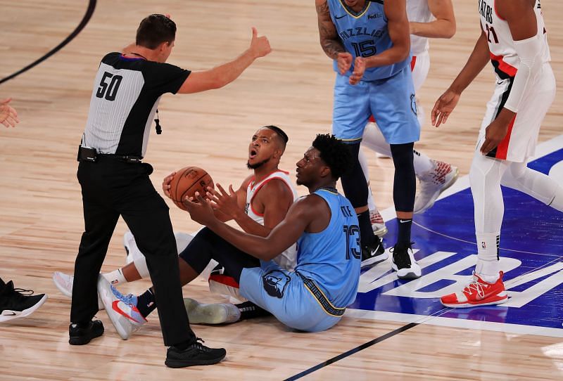 CJ McCollum competes for a loose ball against Jaren Jackson Jr. of the Memphis Grizzlies