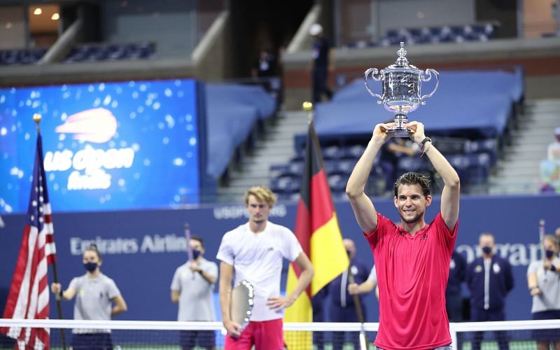 Dominic Thiem holding the 2020 US Open trophy aloft as beaten finalist Alexander Zverev looks on