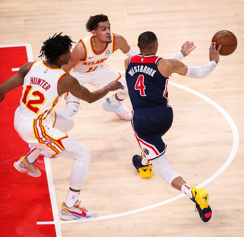 Russell Westbrook #4 of the Washington Wizards passes the ball as Trae Young #11 and Andre Hunter #12 of the Atlanta Hawks defend
