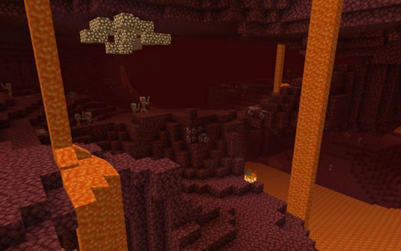 An image of lava flowing down into a lava lake in Minecraft&#039;s Nether. (Image via Minecraft)