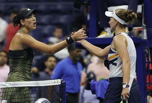 Garbine Muguruza (L) shakes hands with Barbora Krejcikova after their match at the 2021 US Open