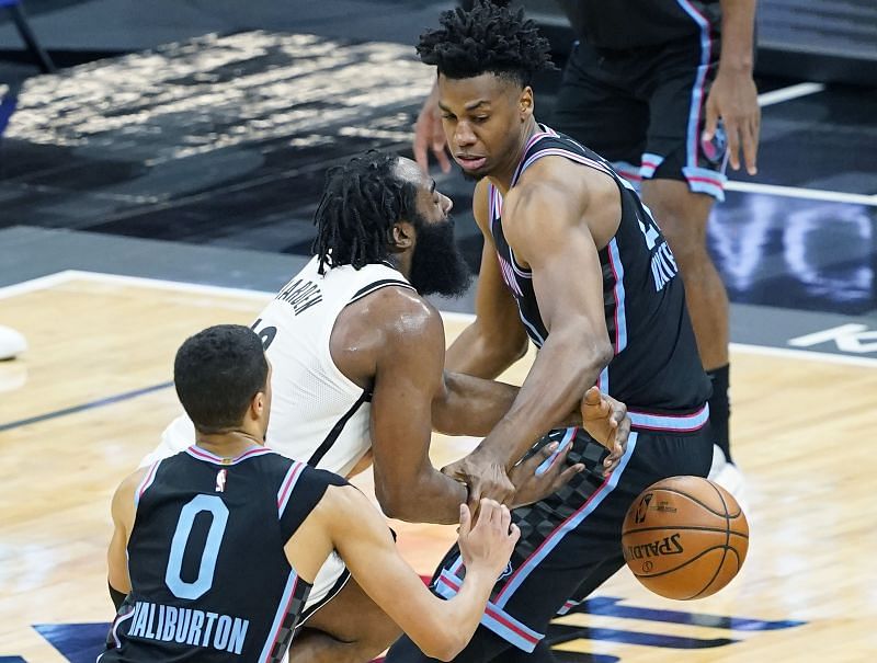 James Harden #13 of the Brooklyn Nets drives against Hassan Whiteside #20 and Tyrese Haliburton #0 of the Sacramento Kings during the second half of an NBA basketball game at Golden 1 Center on February 15, 2021 in Sacramento, California.