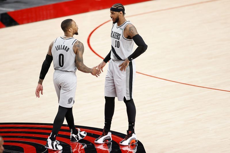 Carmelo Anthony discusses a play with Damian Lillard.