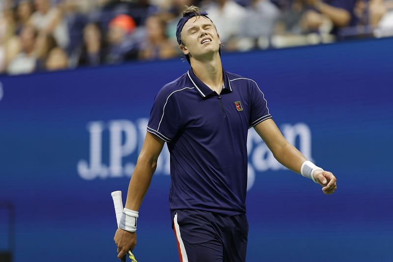 Holger Rune winces in pain during his match against Novak Djokovic