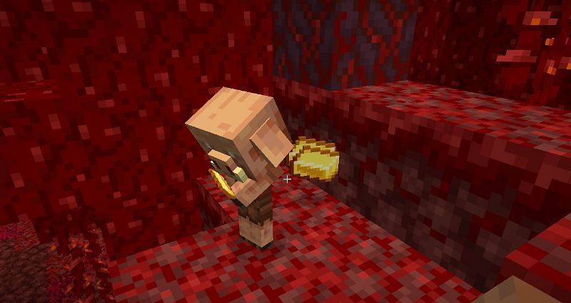 A baby piglin in a crimson forest, holding a gold ingot (Image via Minecraft)