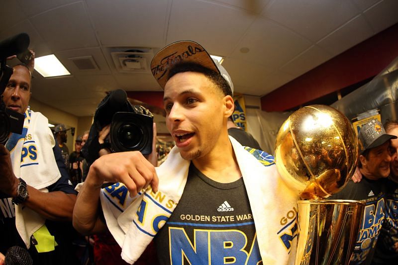 Stephen Curry #30 of the Golden State Warriors celebrates with the Larry O&#039;Brien NBA Championship Trophy