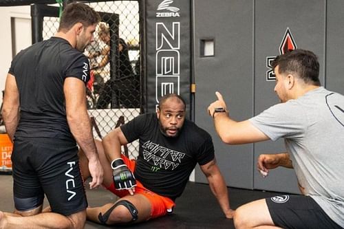 Marcus 'Buchecha' Almeida (left) picking up tips alongside former UFC champion Daniel Cormier (center)