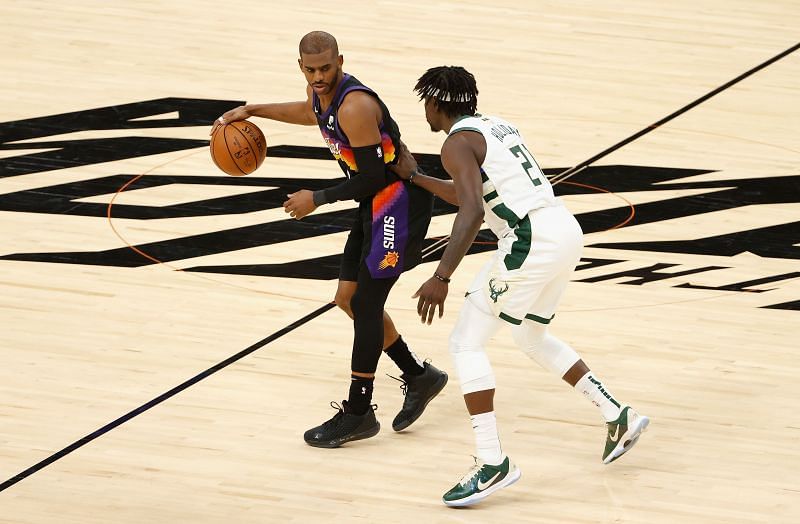 Chris Paul (#3) of the Phoenix Suns handles the ball against Jrue Holiday (#21) of the Milwaukee Bucks.