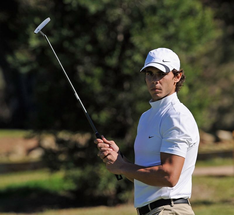 Rafael Nadal poses with a golf club at a recreational event in 2010