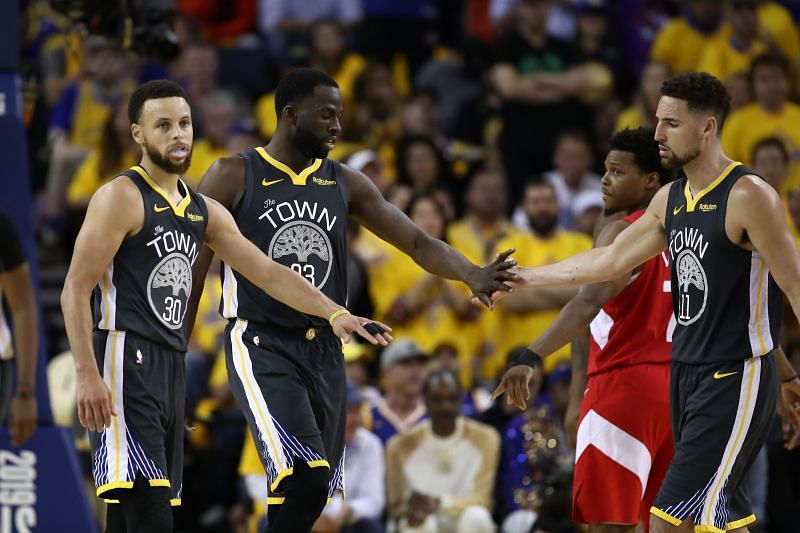 Stephen Curry, Draymond Green and Klay Thompson of the Golden State Warriors high-five each other.