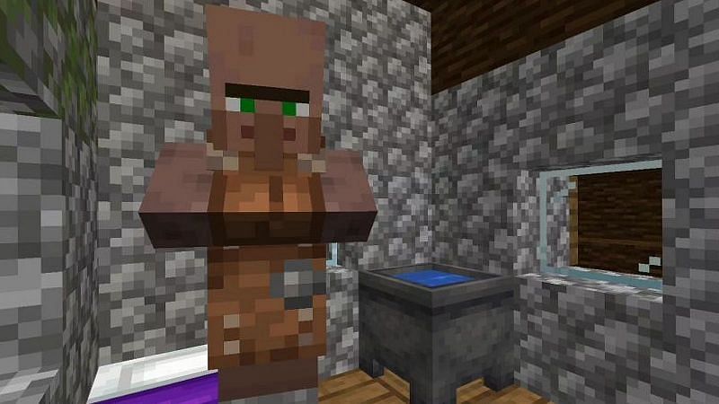 A leatherworker villager stands near a purple bed inside a cobblestone house (Image via Minecraft)