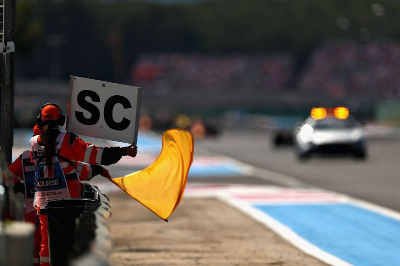 A marshal waves the yellow flag as the Safety Car leads the field during the 2018 French Grand Prix. (Photo by Dan Istitene/Getty Images)