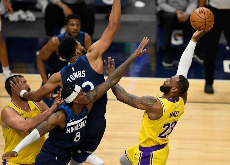 LeBron James attempts to shoot over two Minnesota Timberwolves&#039; players