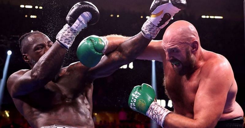 Tyson Fury (right) punches Deontay Wilder (left)