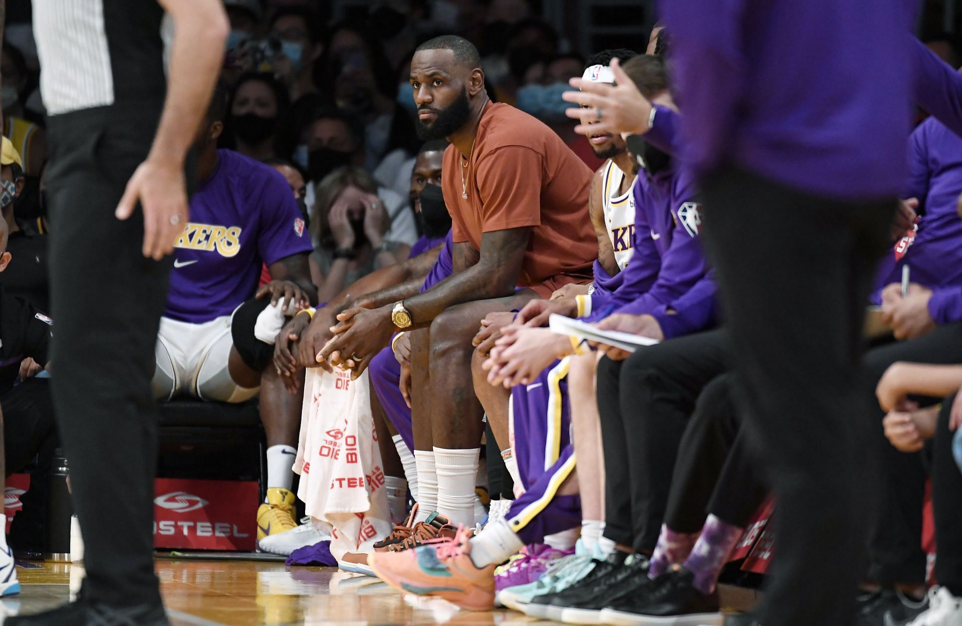 LeBron James #6 of the Los Angeles Lakers follows the action from the bench during a preseason game