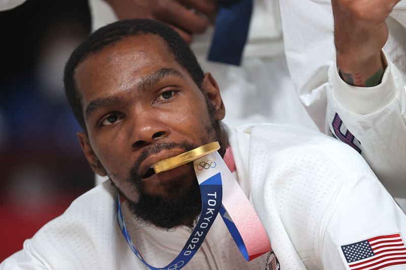 Kevin Durant #7 of Team United States bites his gold medal as he poses for photographs during the Men&#039;s Basketball medal ceremony on day fifteen of the Tokyo 2020 Olympic Games at Saitama Super Arena on August 07, 2021 in Saitama, Japan.