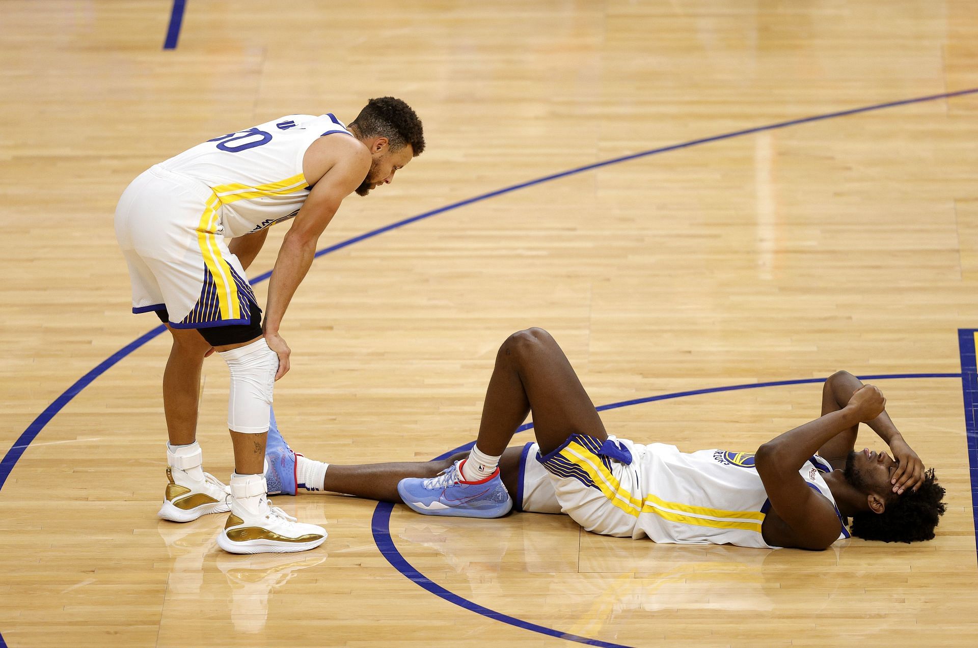 Stephen Curry of the Golden State Warriors checks on James Wiseman after the latter injured himself.