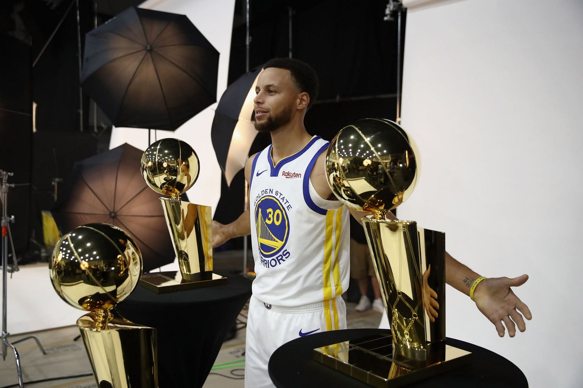 Stephen Curry #30 of the Golden State Warriors poses with three Larry O'Brien NBA Championship Trophies during the Golden State Warriors media day on September 24, 2018 in Oakland, California.